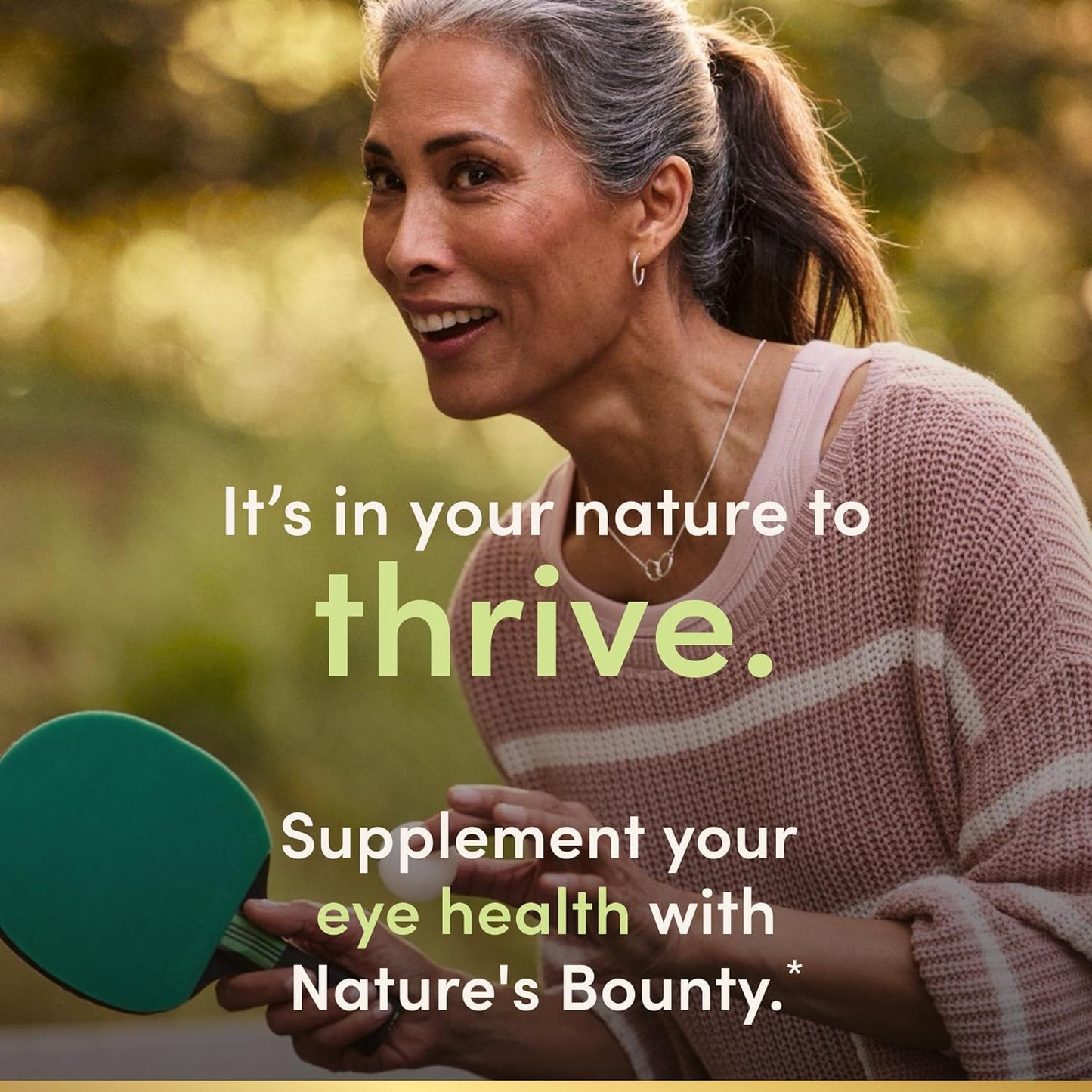 Woman holding a green supplement bottle with text about eye health and Nature's Bounty.
