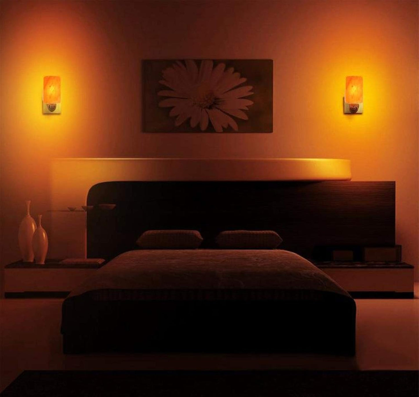 Modern bedroom with a bed, wall art, and decorative vases under warm lighting.