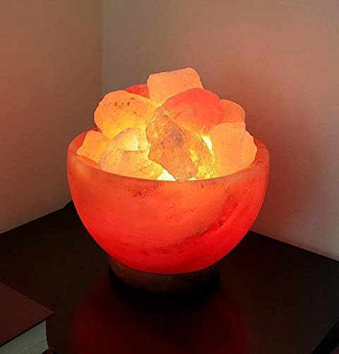Himalayan salt lamp with glowing interior on a dark surface.