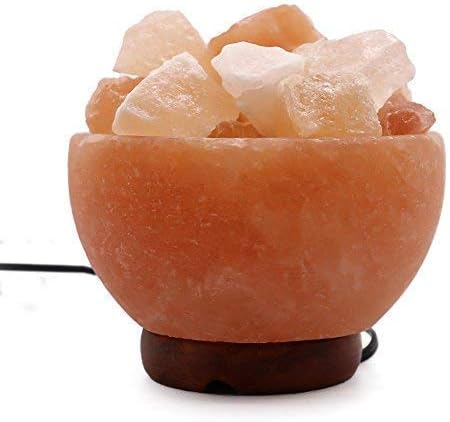 Himalayan salt lamp with chunks of salt on a white background