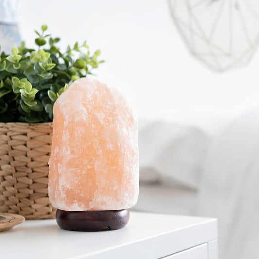 Himalayan salt lamp on a white surface with a blurred background
