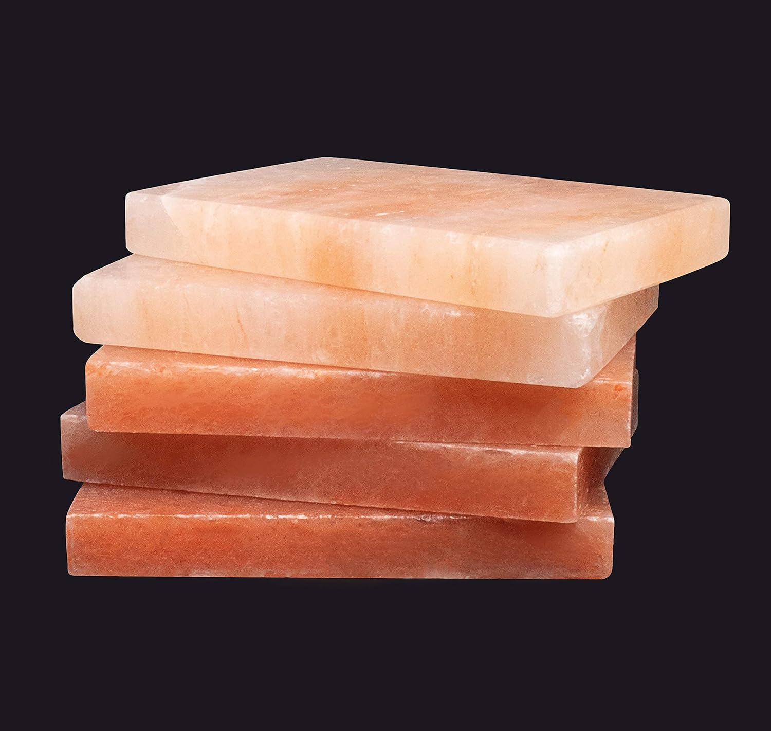 Stack of pink Himalayan salt blocks on a black background
