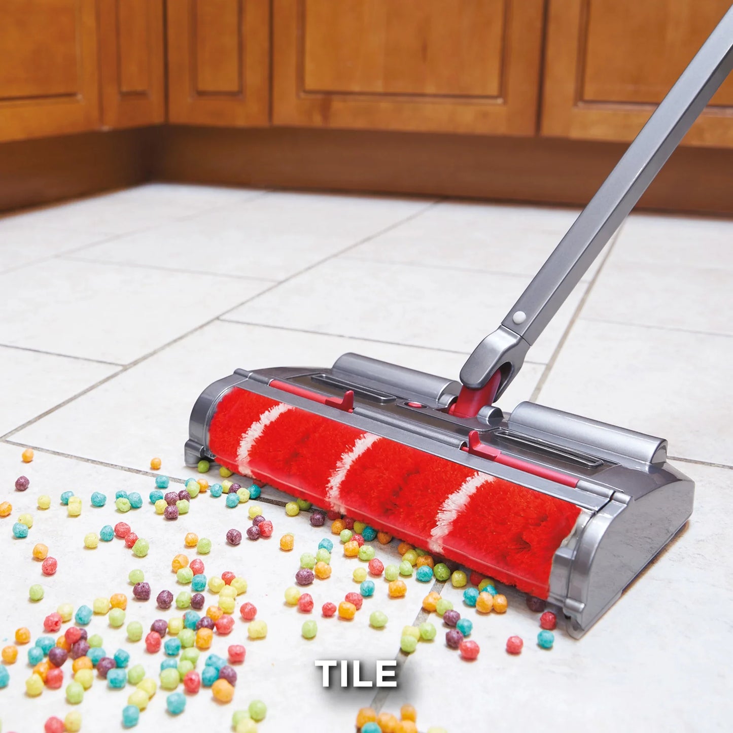 Cleaning tool with red roller cleaning a tiled floor with colorful beads.